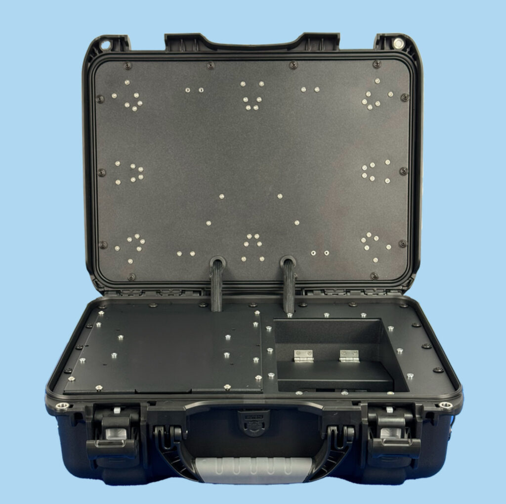 ** Open black equipment case with mounting points and compartments on a blue background.
